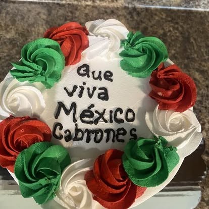 Cake with red, white, and green buttercream rosettes and a festive message, inspired by the colors of Mexico.